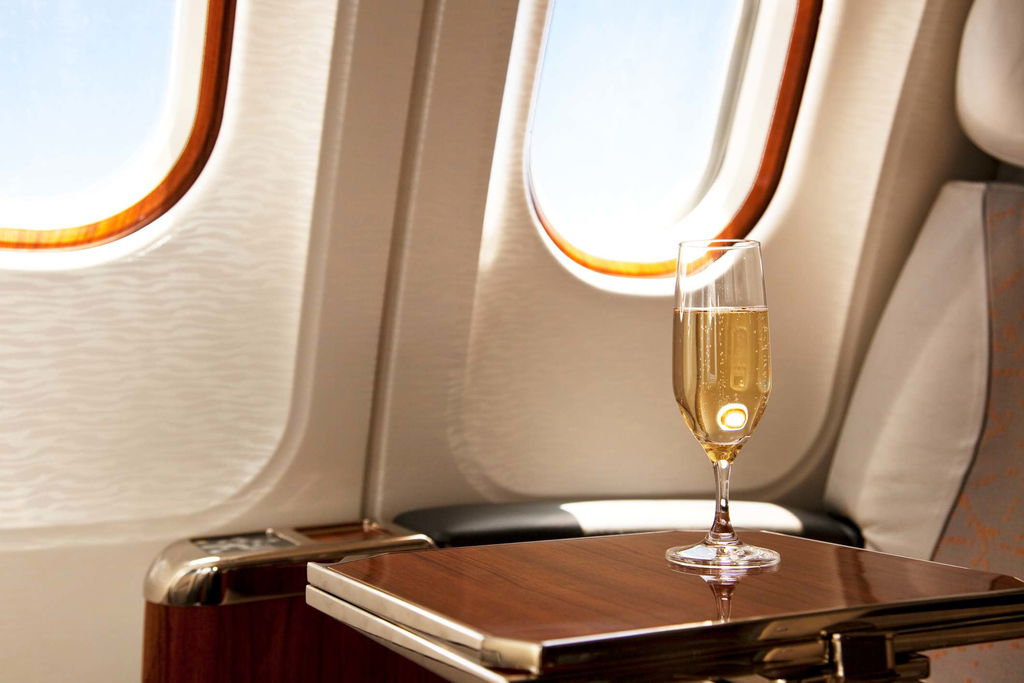 business class seat with glass of champagne