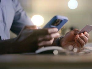 man holding phone and credit card