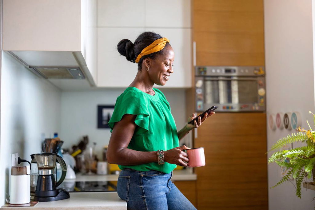 woman on her phone standing in kitchen