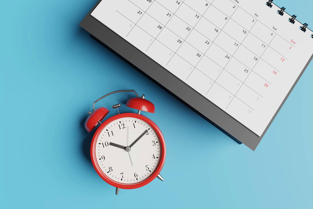 alarm clock next to a calendar